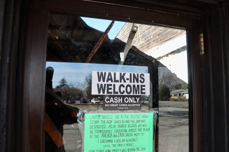 The collapsed roof is seen through the front door of the Barbershop at Peddler’s Village on Route 24. The roof gave way under the weight of the snow from the Feb. 23 blizzard. The green sign directs customers to the Anchor & Iron Salon across the parking lot, where three barbers are now cutting hair again. BILL SHULL PHOTOS